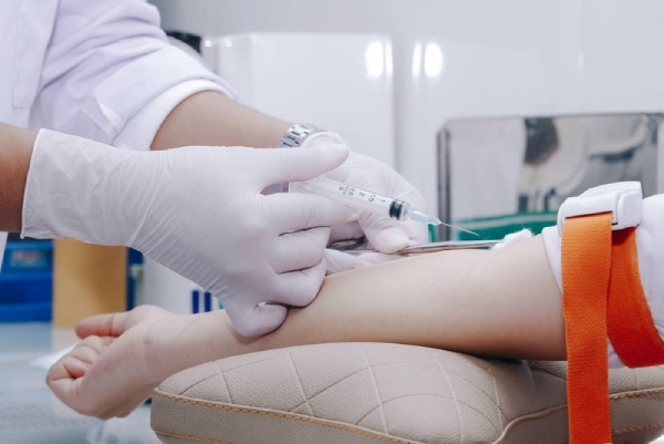 Bác sĩ thực hiện lấy máu của mẹ bầu để làm xét nghiệm máu